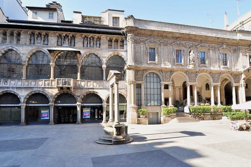 Un edificio storico con finestre ad arco e una fontana centrale. 5