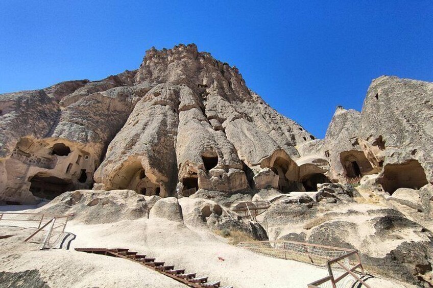 Un paisaje rocoso con grandes formaciones de roca y una escalera que sube a una zona más elevada. 1