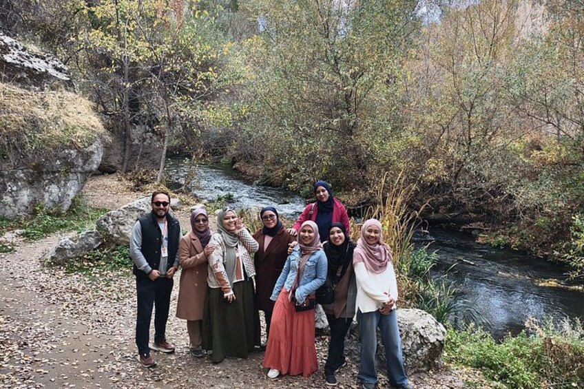Eine Gruppe von Menschen steht an einem Fluss in einem bewaldeten Gebiet. 1