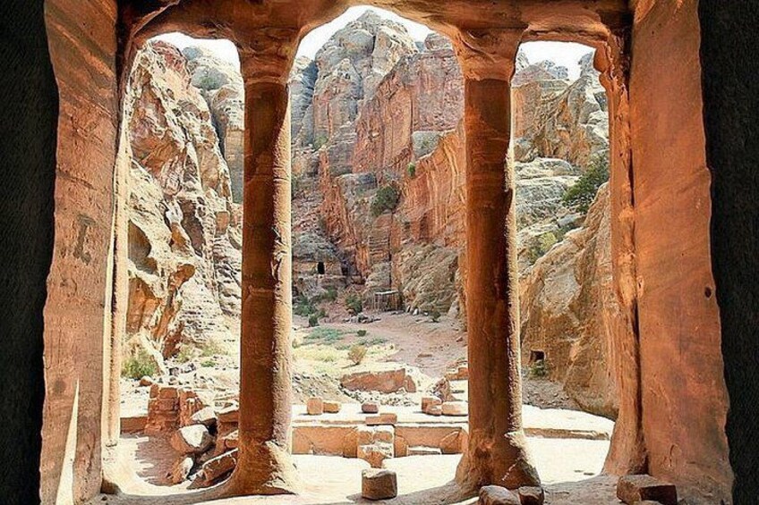 Cañón con formaciones rocosas y una vista a través de un arco de madera. 4