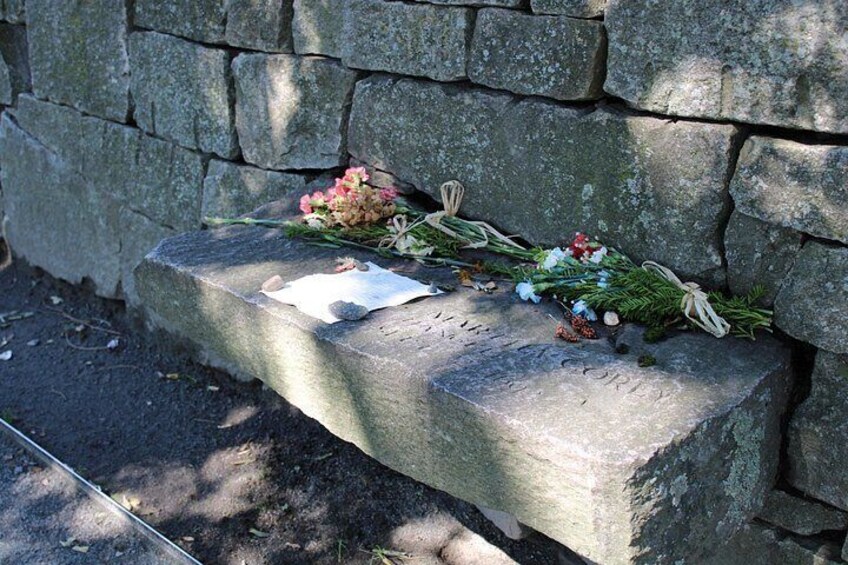 A stone bench with flowers and a note. 3