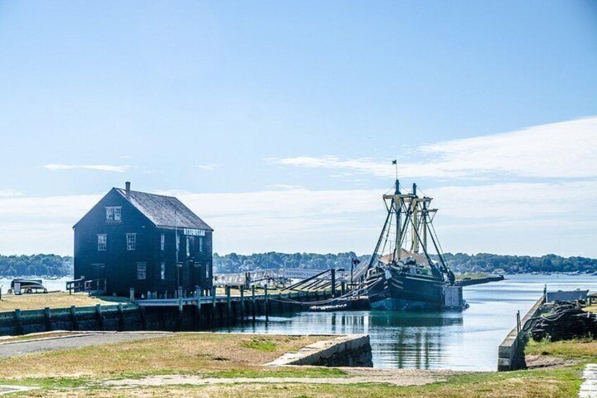 A dock with a large fishing boat, a wooden building, and a calm water body. 2