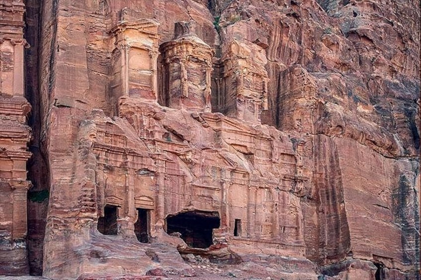 Ancient rock-cut architecture with multiple niches and a large cave-like opening. 5