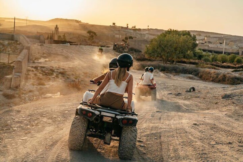 Una persona conduciendo un cuatrimoto por un camino de tierra, con otra persona al fondo. 1