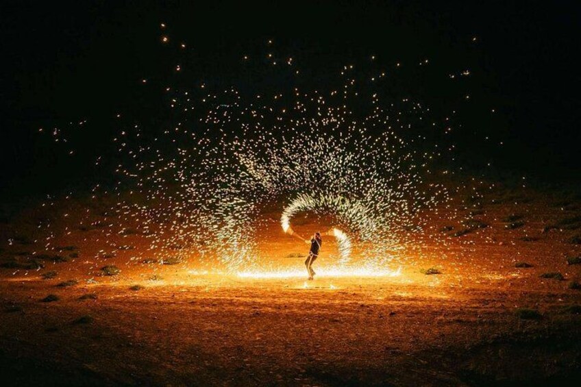 A person standing in a field with sparks flying around them. 5