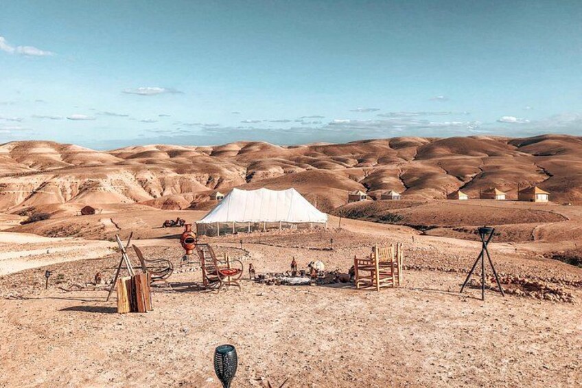 A desert landscape with tents, a white tent, and a tripod. 4