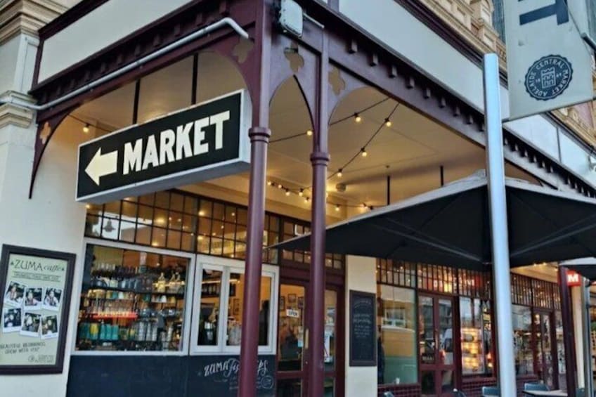 Een marktraam met een pijl naar links, een winkel met glazen ramen, en een overdekt terras. 3