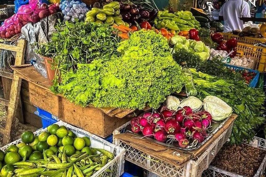 A market stall with various vegetables like lettuce, radishes, and cucumbers. 2