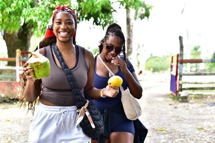 Two people walking outdoors, one holding a drink and the other holding a fruit. 4