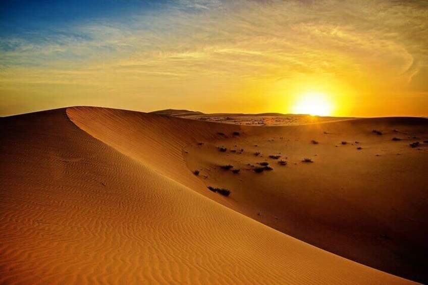 Et ørkenlandskab med sandklitter og en solnedgang. 4
