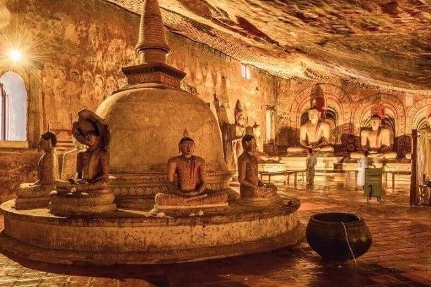 A cave temple with Buddha statues, a stupa, and intricate carvings. 3