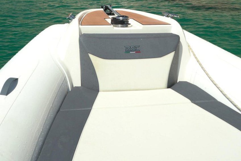 A boat with a white hull, a brown deck, and a gray and white seating area. 4