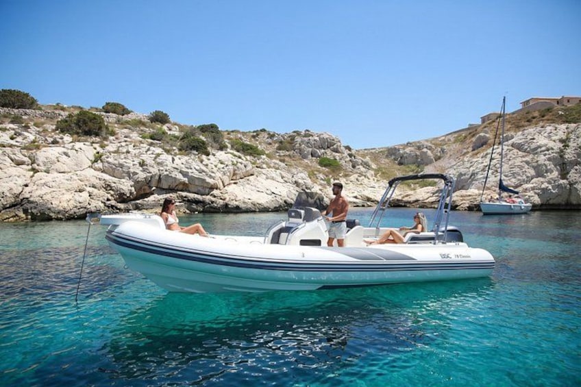 A boat on clear turquoise water with rocky hills in the background. 3