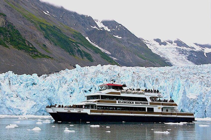 A cruise ship named 'Klodnice Express' with passengers, sailing near a glacier. 1
