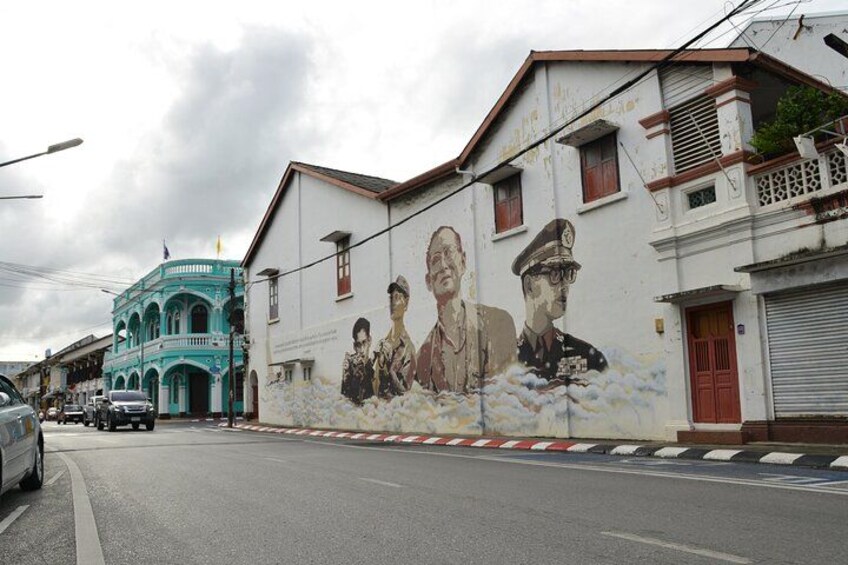 A street with a mural, a teal building, and a closed shop. 4