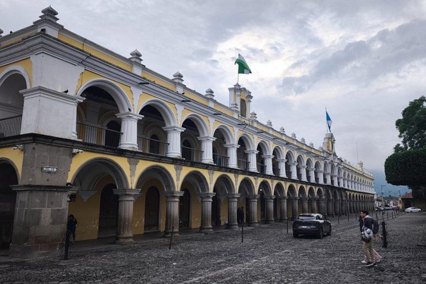 A historic building with yellow and white architecture, featuring multiple arches and columns. 2