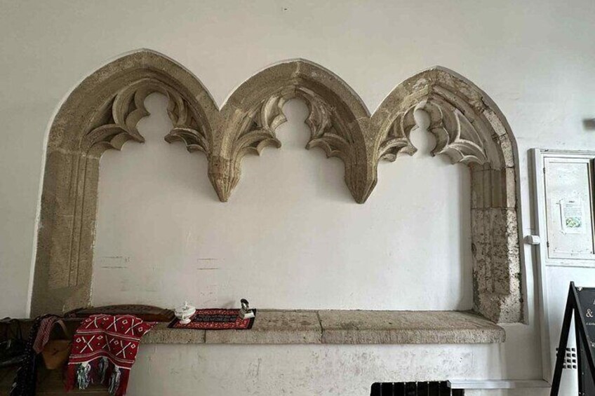 A stone bench with a decorative archway above it. 3