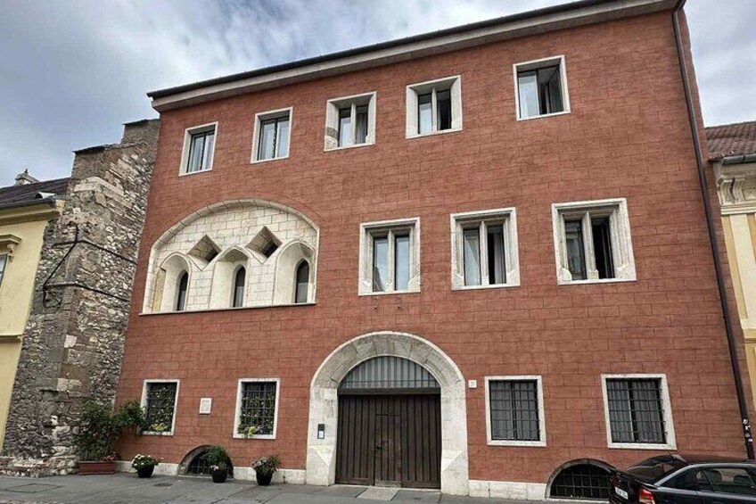 A red brick building with arched windows and a central entrance. 4