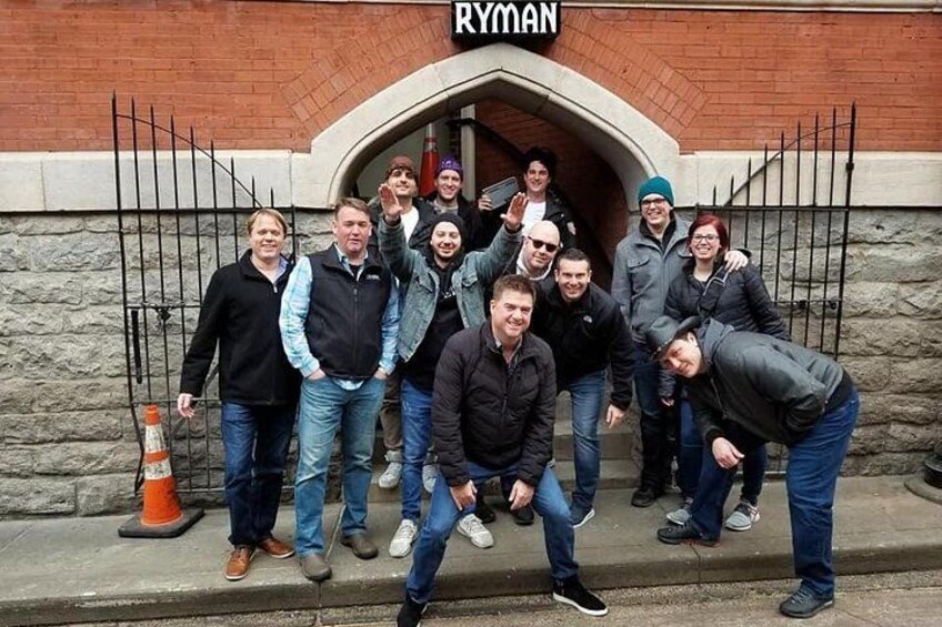 Un grupo de personas frente a un edificio con un letrero que dice 'RYMAN'. 3