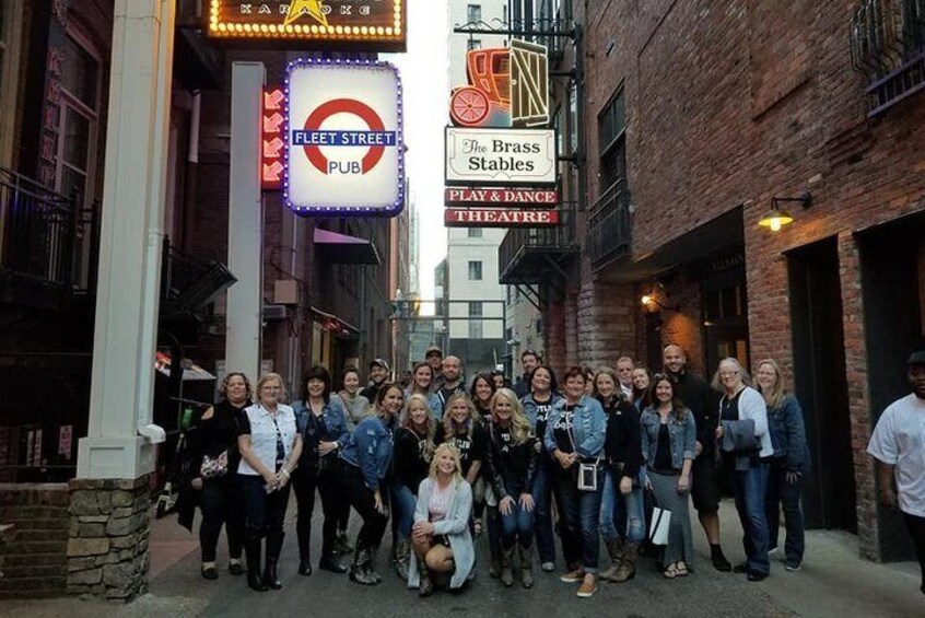 A group of people posing in front of a pub and a theatre. 5