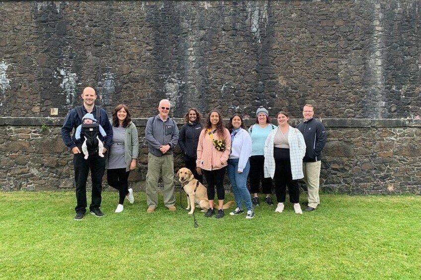 A group of people standing in front of a stone wall. 2