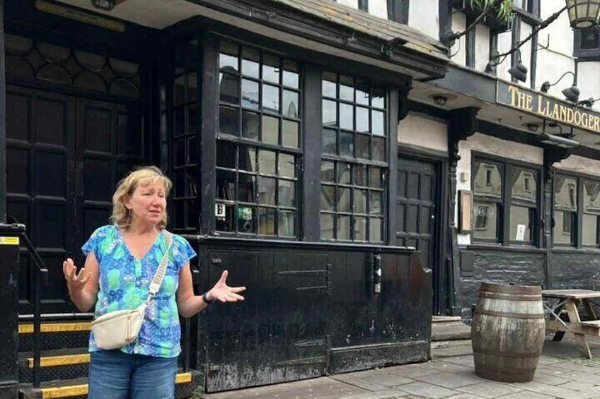 Una donna in piedi di fronte al Landoger Inn, che gesticola con le mani. 1