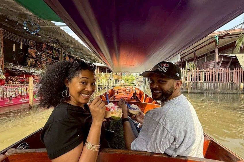 Two people in a boat with a market in the background. 2