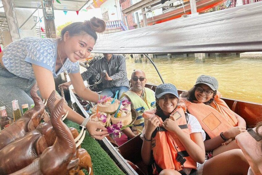 A group of people on a boat, some wearing life jackets, with a person serving food. 4