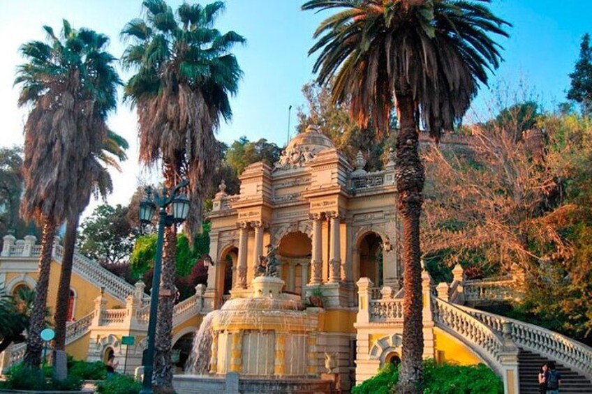 A historic fountain with a balustrade, palm trees, and a building with classical architecture. 3