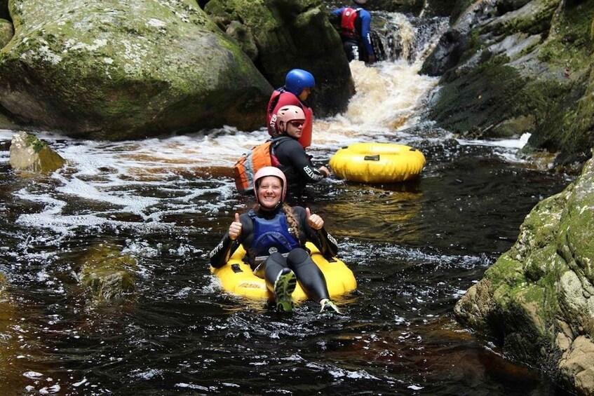 People rafting on a river surrounded by rocks. 1