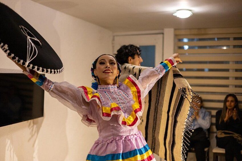 Une personne vêtue d’un costume traditionnel aux couleurs vives, portant un sombrero noir. 2