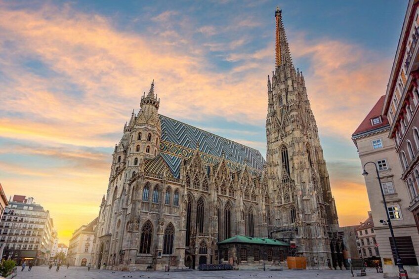 En historisk katedral med detaljerad gotisk arkitektur, ett markant torn och en modern glasbyggnad. 1