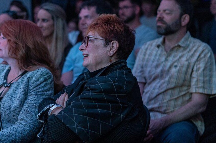 Audience member laughing watching a comedy show at In Stitches Comedy Club 4