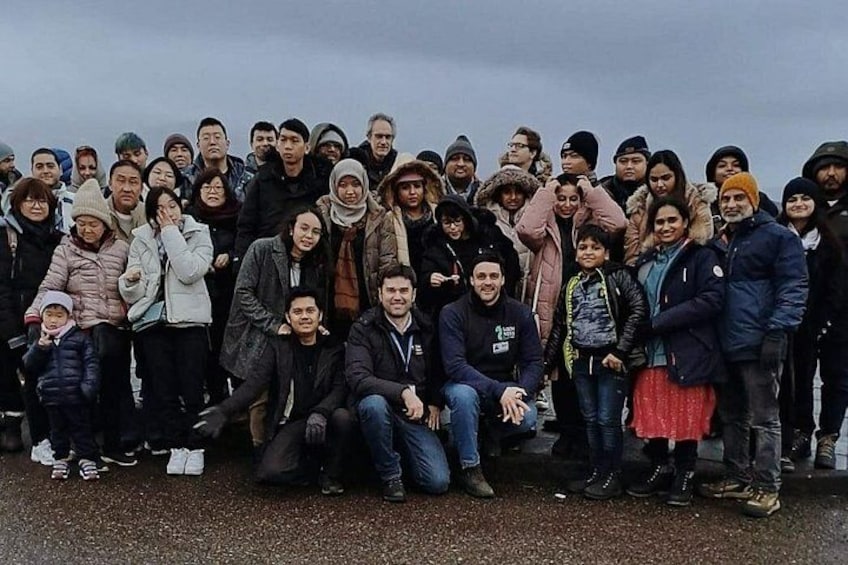 A group of people posing for a photo outdoors. 2