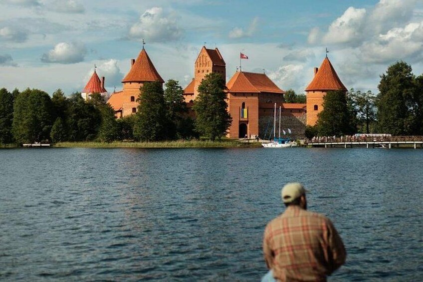 A castle with red roofs by a calm lake. 1