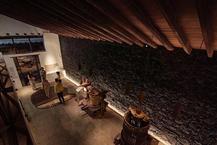 An interior space with a stone wall, wooden ceiling, and a circular seating area. 3
