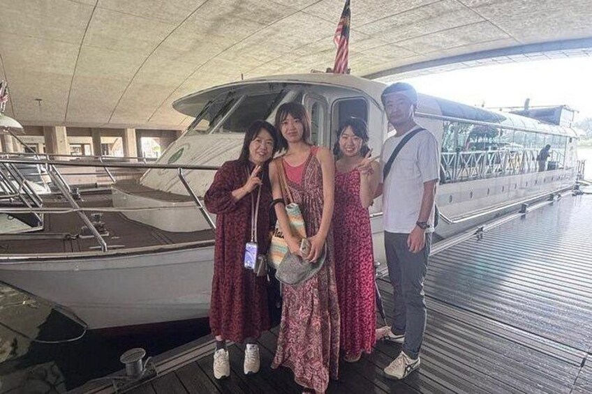 Un groupe de personnes posant devant un bateau sur lequel flotte un drapeau américain. 5
