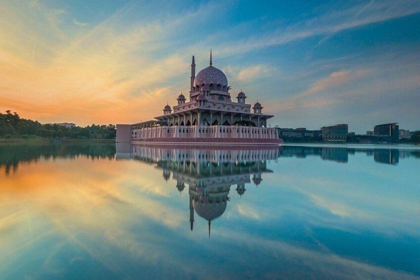 Une mosquée dotée d’un grand dôme et de minarets, dont le reflet se mire sur une étendue d’eau calme. 1