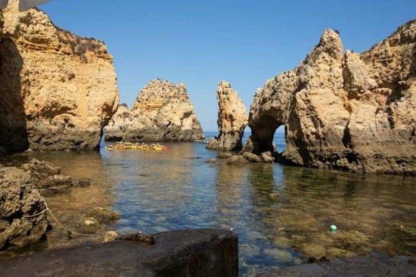 A rocky coastline with clear water and a small boat. 4