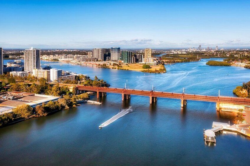 Un río con un puente, edificios y una barca. 2