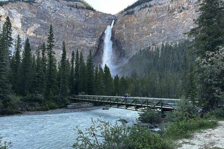A waterfall, a river, a bridge, and a forested mountain. 2