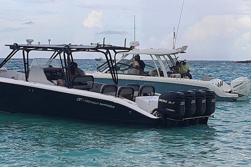 A boat named 'Midnight Express' with two outboard motors, a cabin, and a deck area. 2