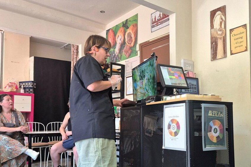 A person presenting at a conference with a laptop and a projector screen. 2