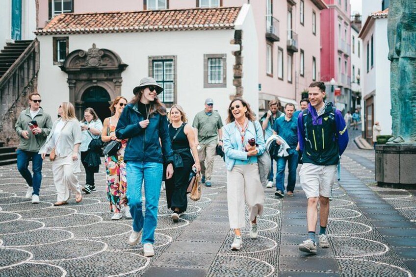 A group of people walking on a cobblestone street in a historic town. 1