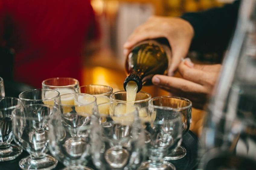 Iemand giet een vloeistof in een glas. 5