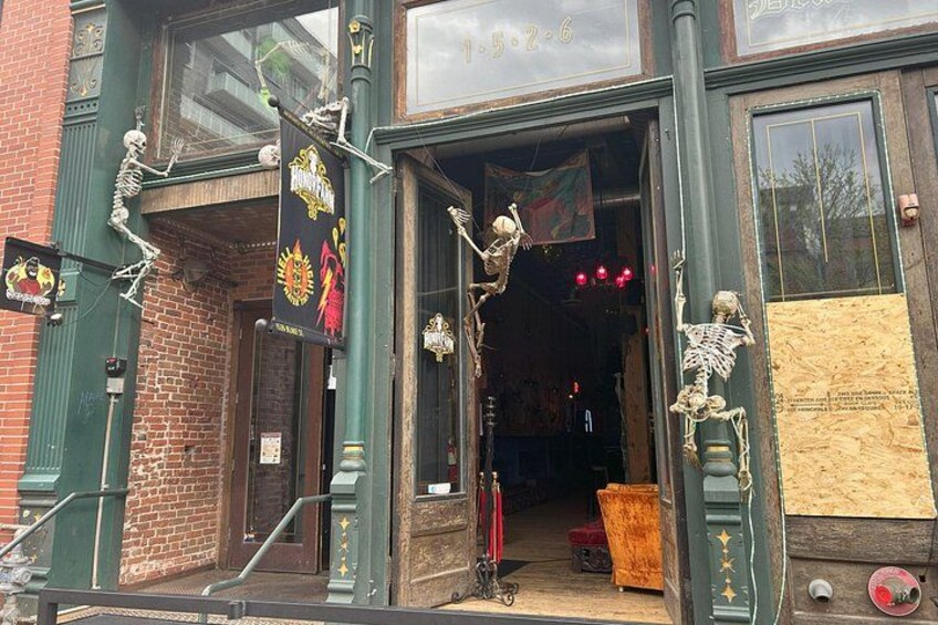 A building entrance with skeleton decorations, a brick wall, and a wooden door. 3