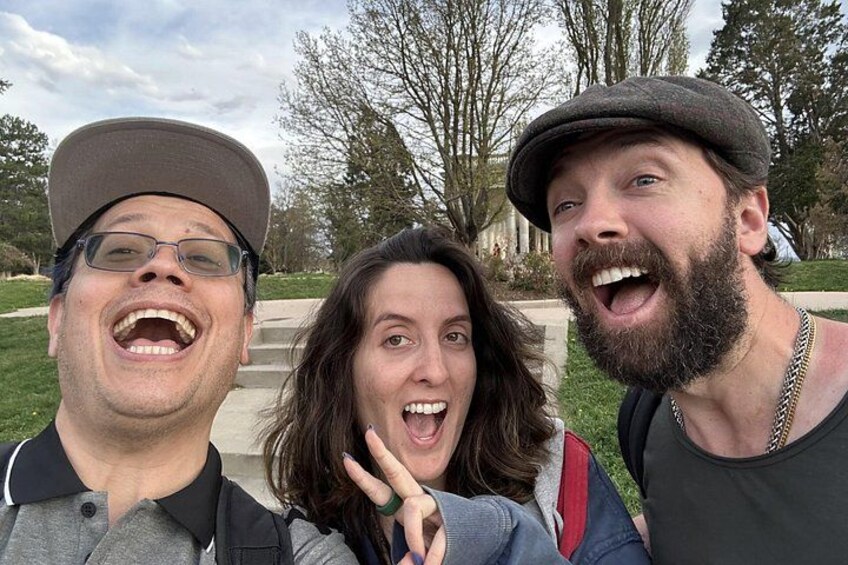 Three people outdoors, a grassy area, and trees in the background. 3