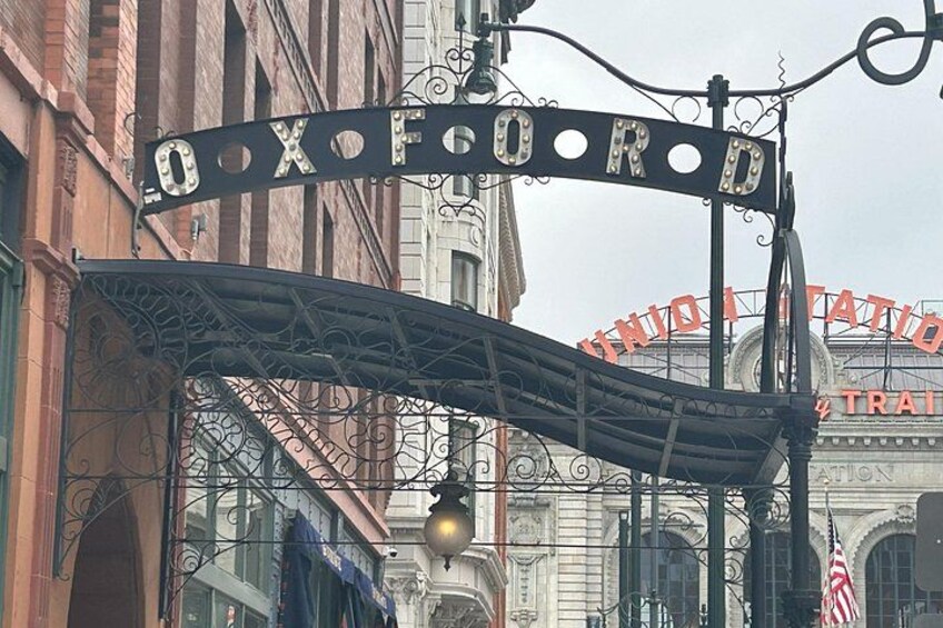 A wrought iron archway with the inscription 'OXOFORD' and a sign for 'UNION STATIO' in the background. 2