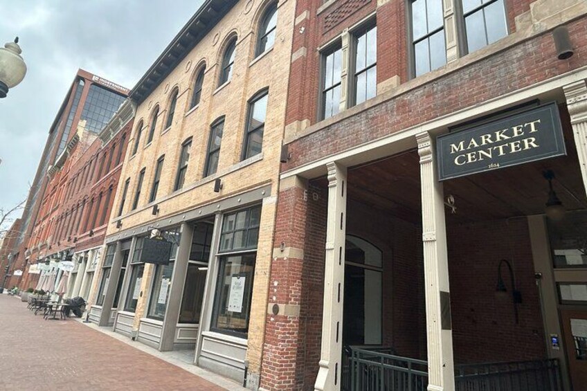 A brick building with a sign reading 'Market Center' and storefronts with awnings. 4