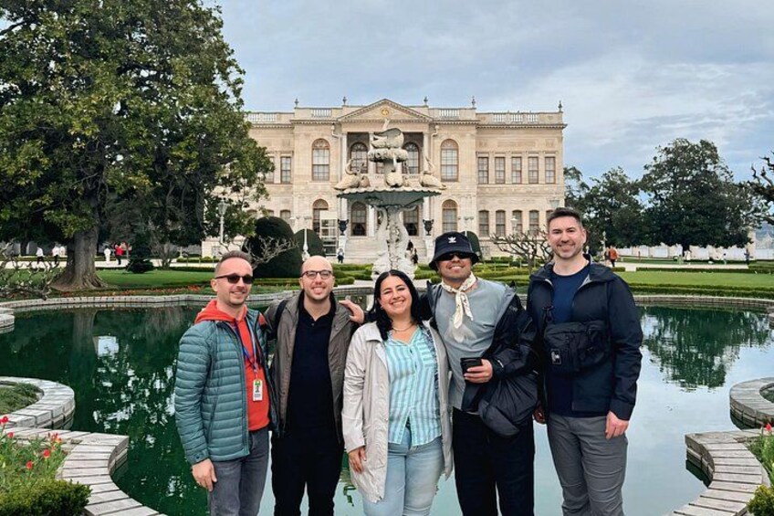 Un groupe de personnes se tient devant un grand bâtiment orné d’une fontaine. 5